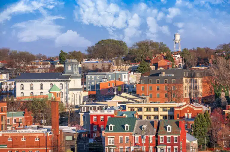 A view of one of the many Richmond, VA neighborhoods, featuring large brick townhouses and a water tower in the distance