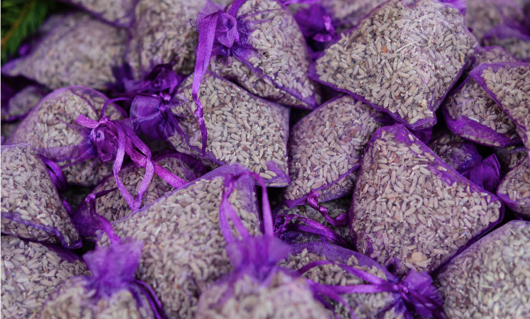 Dozens of purple lavender sachets are stacked together before being packed with seasonal clothes in order to repel moths in storage containers.