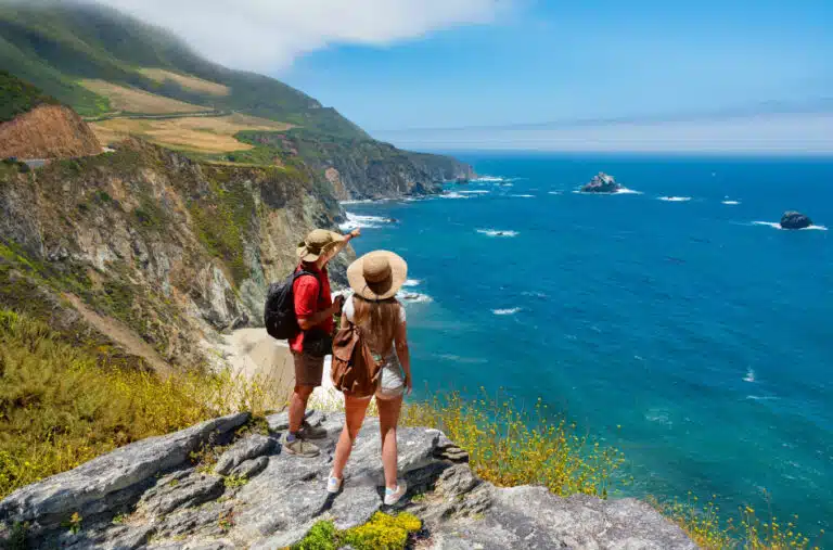 Hikers looking over the Pacific ocean from cliffs in California
