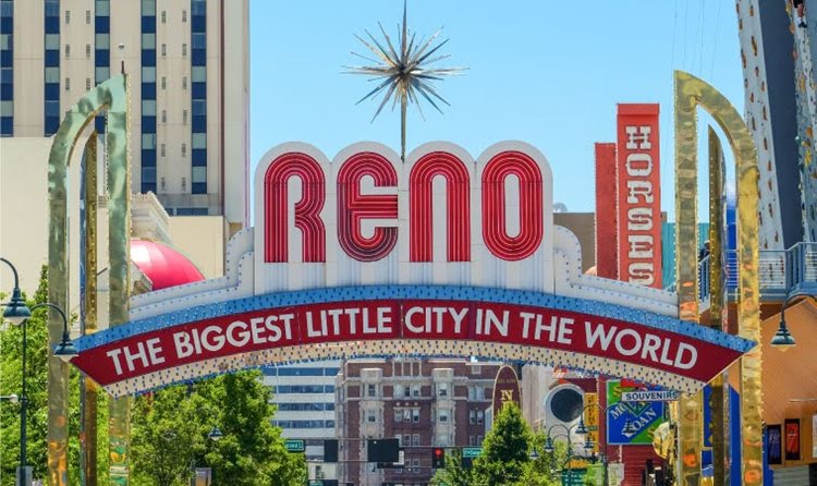 The iconic Reno Arch spans Virginia Street at Commercial Row in Reno, Nevada. The top of the sign reads, “RENO,” and below it are the words, “THE BIGGEST LITTLE CITY IN THE WORLD.”