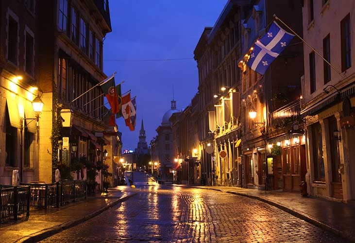 The cobblestone alleys of Old Montreal at nighttime.