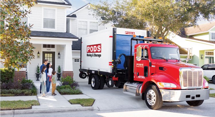 A driver positions a PODS portable moving container in a residential driveway for a family that is moving to Canada from the U.S.