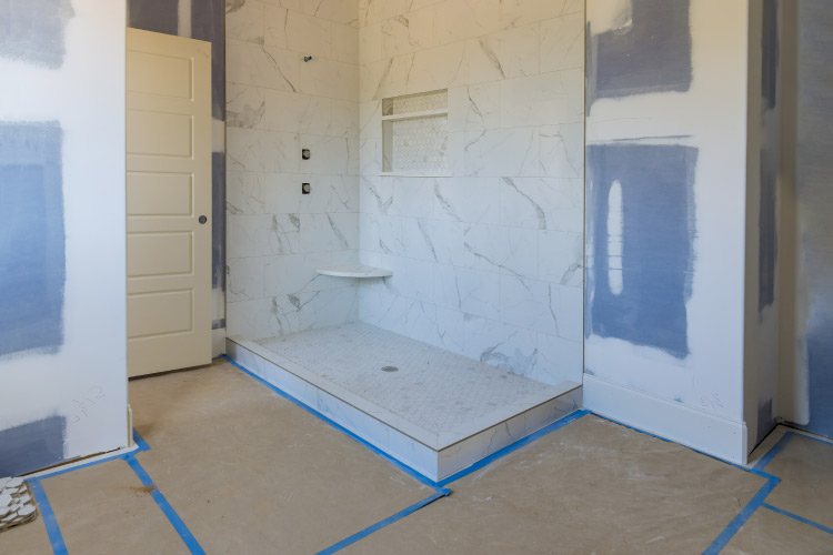 A half bath that is in the process of being converted to a whole bath. The shower is nearly complete and the walls are ready for either paint for tile application.