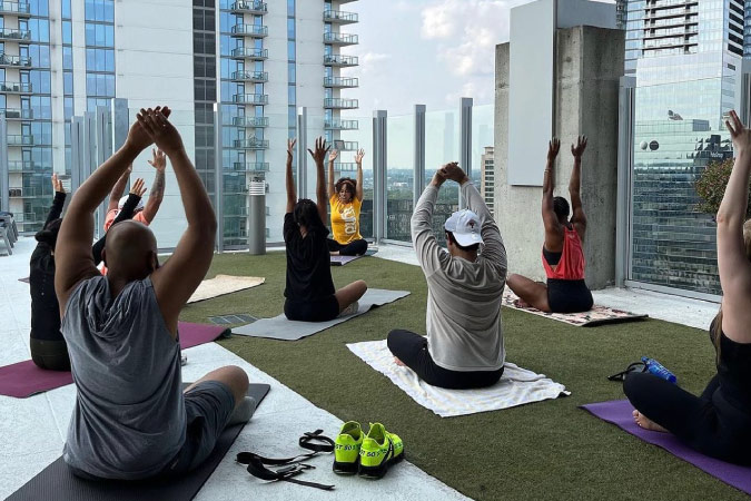 Residents enjoy a rooftop yoga session at SkyHouse Buckhead, a luxury apartment community in Atlanta, Georgia.