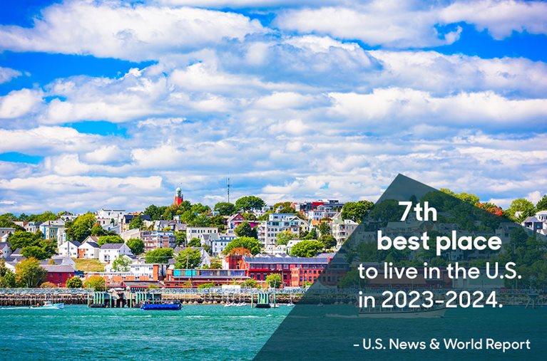 View of the beautiful and vibrant city of Portland, Maine, on a sunny summer day, as seen from the water. The overlaid text reads “One of the top 10 best places to live in the U.S. in 2023-2024. (U.S. News & World Report).”