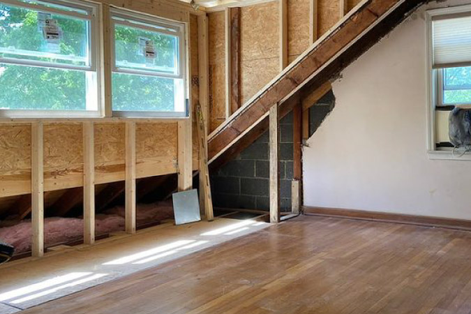 A partially remodeled attic featuring newly installed wood floors.
