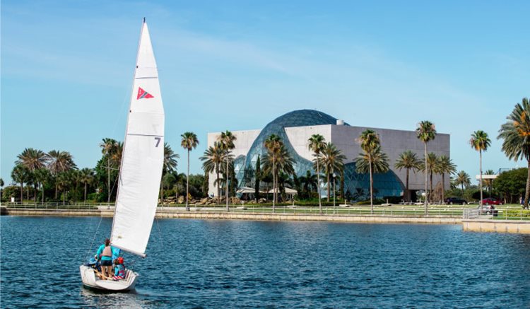 A sailboat is cruising by The Dalí Museum in downtown St Petersburg, Florida, on a sunny day.