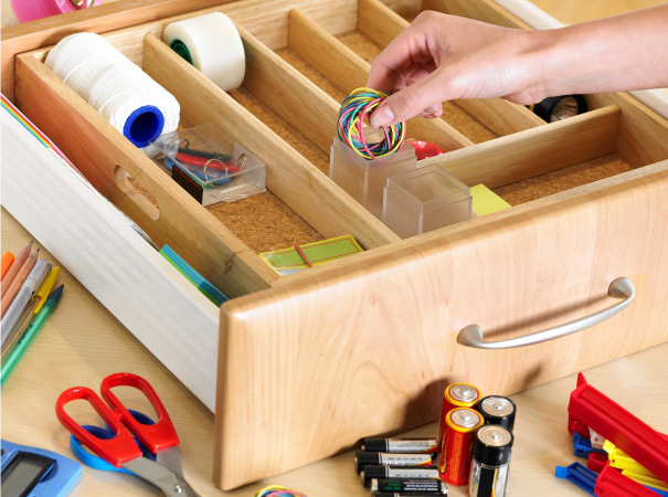A drawer broken into dividers to more neatly hold like things such as yarn, rubber bands, and rolls of tape