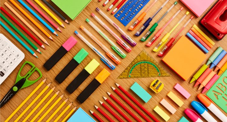 Neatly organized pencil, penis, protractors, sticky notes, and other items you would find in a math classroom on a table.