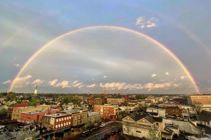 View of the city of Montclair, New Jersey, beneath a rainbow in the sunny moments after a rainstorm. 
