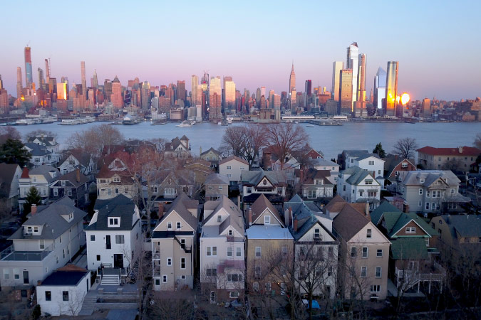 Rows of residential homes in Weehawken, New Jersey, with a view of New York City from across the river.