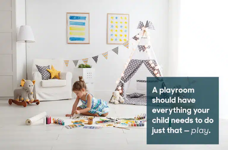 little girl painting on floor in playroom
