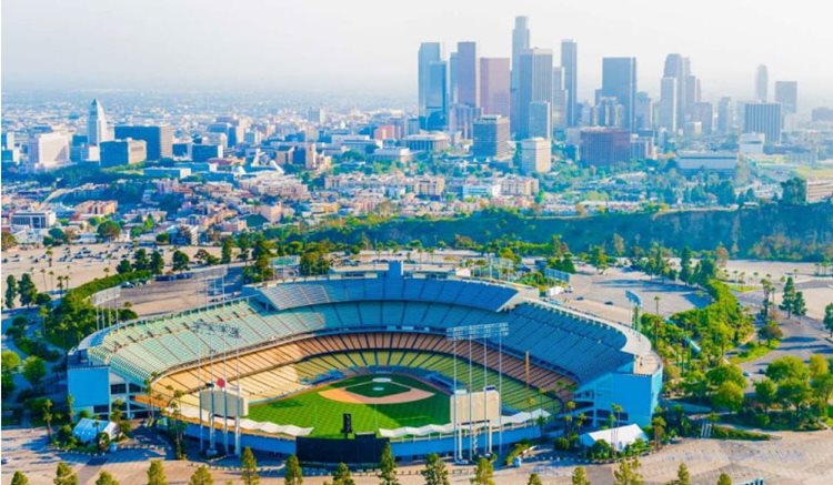 Aerial view of Echo Park with Dodger Stadium in the foreground and the Downtown L.A. skyline in the distance.