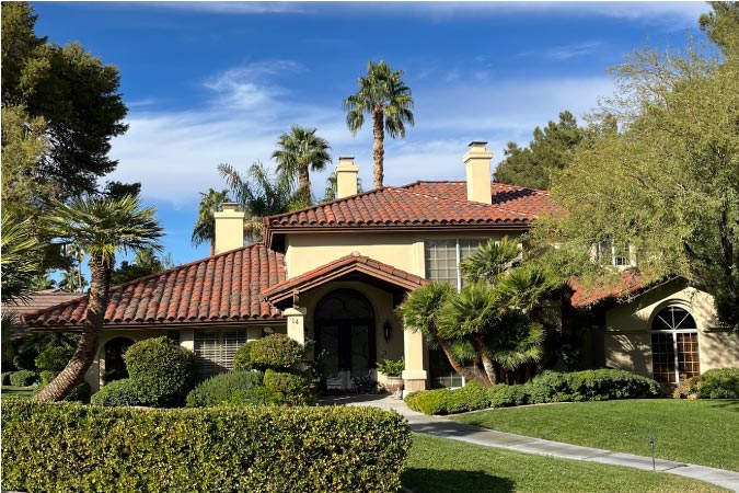 A luxury single-family home in the Green Valley North neighborhood of Las Vegas, featuring a lush front yard and clay tile roof. 