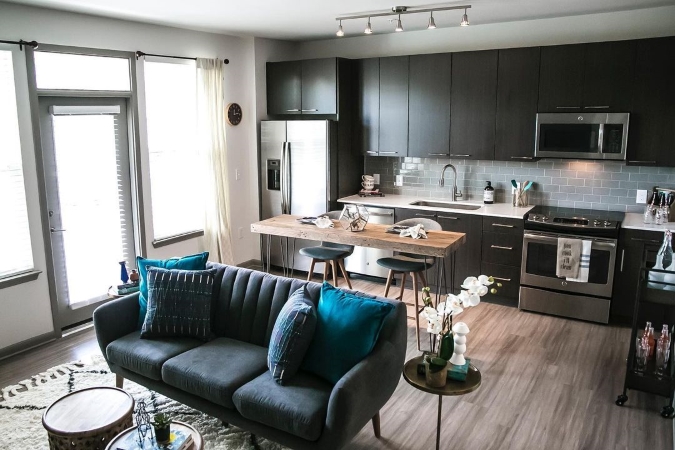 Interior view of an apartment in Glenwood at Grant Park in Atlanta, Georgia. The apartment features an open kitchen that connects with the living room and plenty of windows to let in natural light.