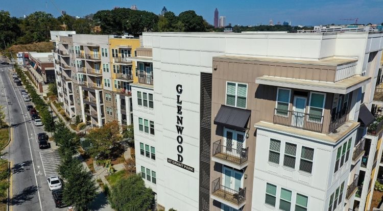 Rooftop view of the Glenwood at Grant Park luxury Atlanta apartment building. The building features a clean white and beige exterior with covered balconies for some apartments.
