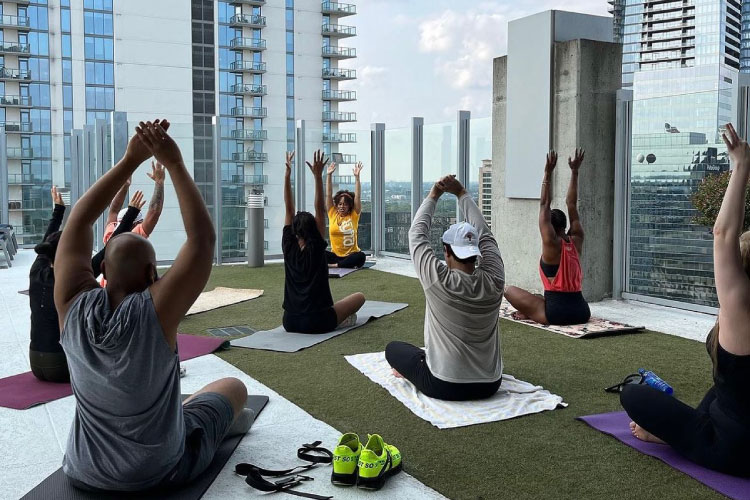 Residents participate in rooftop yoga at the SkyHouse Buckhead apartment building in Atlanta, Georgia. A glass rail allows for an unobstructed view of the surrounding city. 