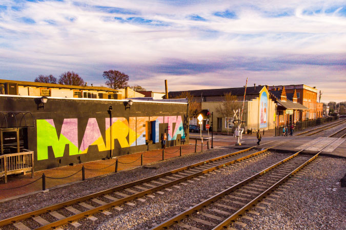 A colorful mural with the word “MARIETTA” painted in block letters against a black background on the side of a building in Marietta, Georgia. 