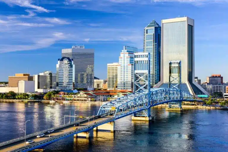View of city buildings in Downtown Jacksonville on a sunny day from across the St. Johns River