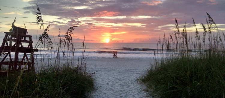 A couple walks along the Atlantic Beach in Jacksonville, Florida, during sunset