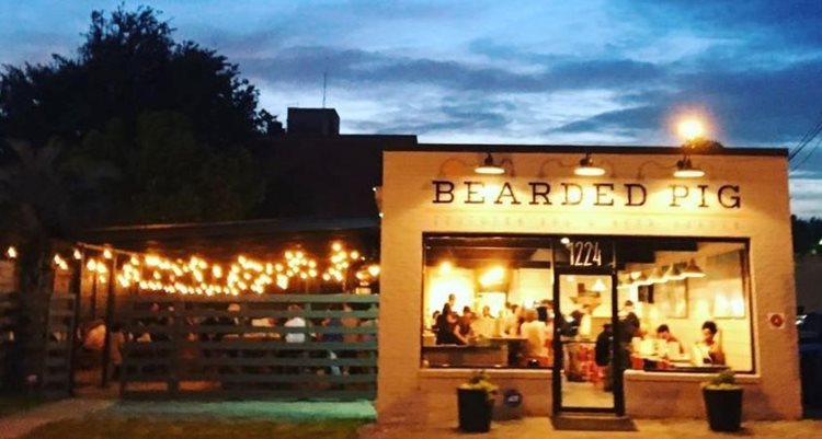 The Bearded Pig is bustling, both inside and out on the lighted patio, just after sunset.