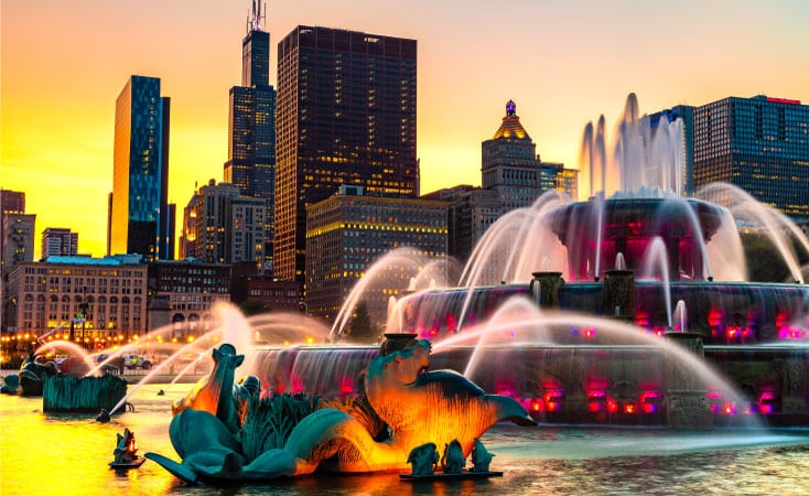 Bright hues from a sunset reflect off the waters of Buckingham Fountain in Chicago, IL.