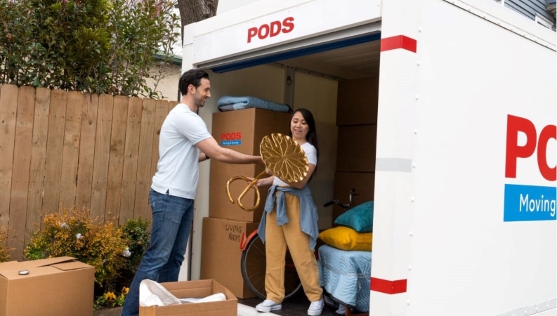 Couple using a PODS portable container to organize and declutter their home.