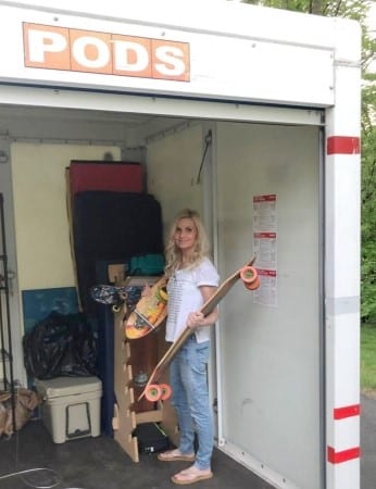 Michele from Hello Lovely is standing in a PODS portable container holding her son's skateboards as she helps to load it up.