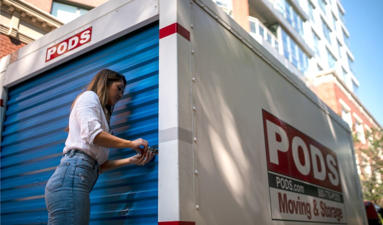 A woman securing a lock on her PODS portable moving container