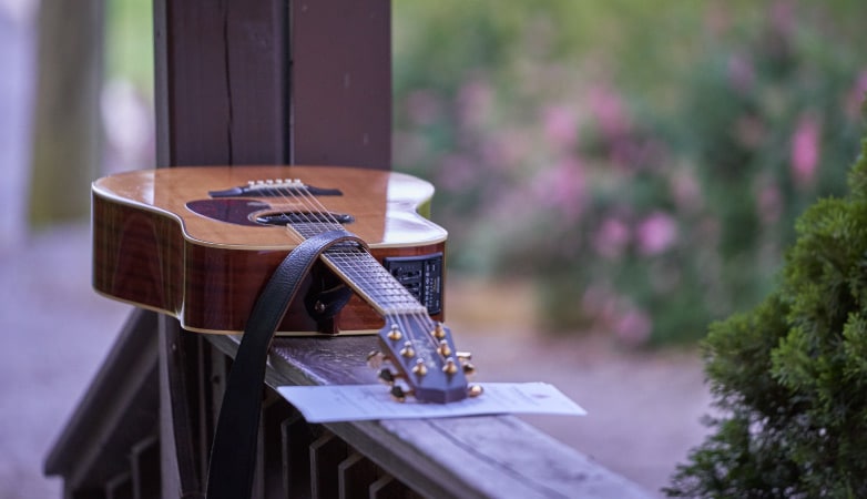 acoustic guitar on a porch railing