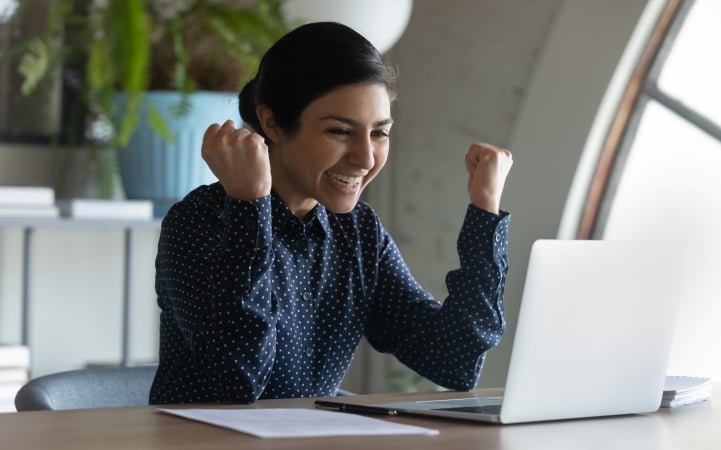 a new employee celebrates after seeing what relocation services their new employer is offering