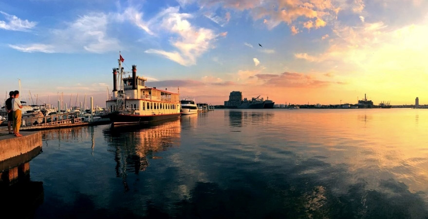 A couple admires the sunset and waterfront view at a marina in Canton, one of the best Baltimore neighborhoods. 