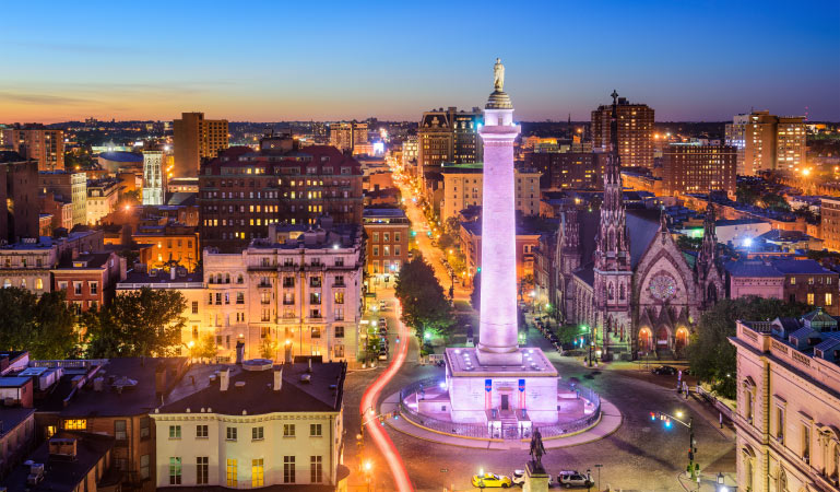 A nighttime aerial view of the original Washington Monument in Baltimore’s downtown neighborhood of Mount Vernon.