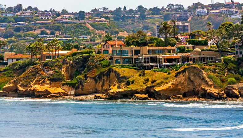 The community of La Jolla in San Diego, California. Large residential homes sit atop rocky cliffs above the San Diego coast.