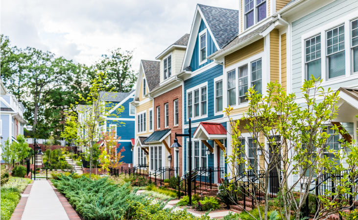 Colorful townhouses in a row with fresh lawns and greenery.