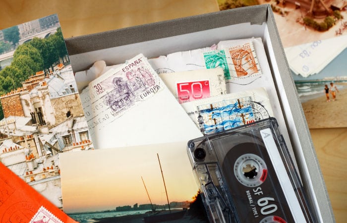 A box of sentimental items, including letters, postcards, and a cassette tape.