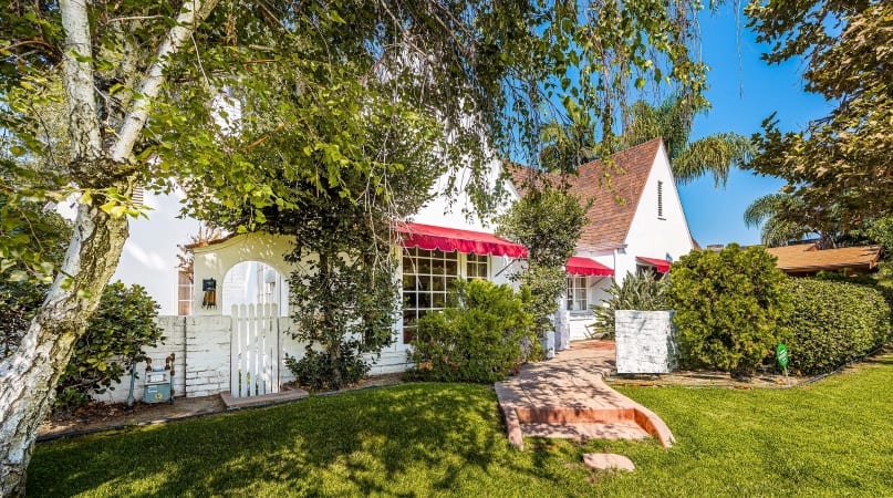 A white mid-century modern home with bright red awnings in the Colony Historic District of Anaheim, CA