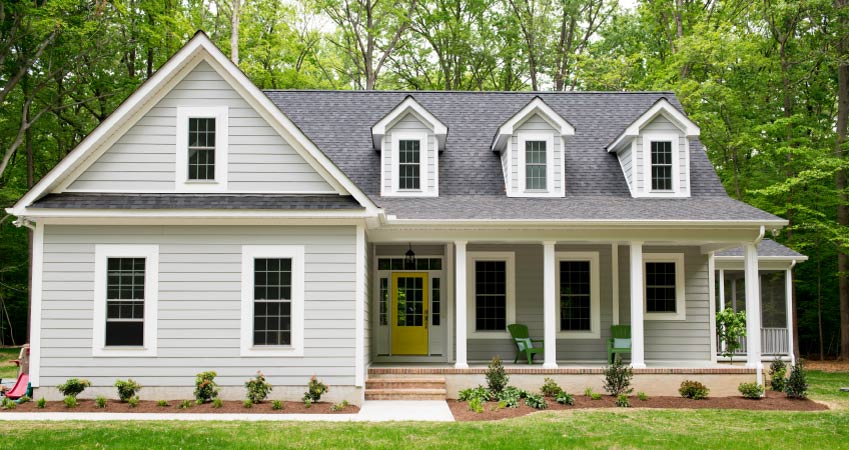 gray Cape Cod style house with yellow door