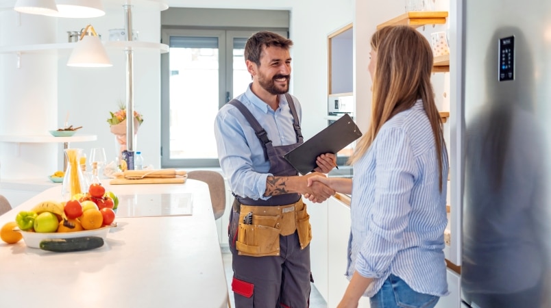 A woman shaking hands with a home remodeling contractor who is going to handle her pantry remodel.