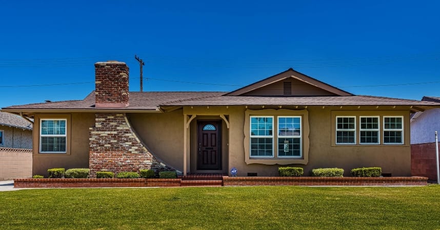 A well-maintained brown house in West Anaheim with a stunning fireplace chimney that can be seen from the outside front of the house