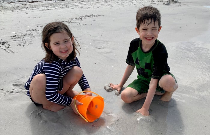 two happy kids playing on a beach