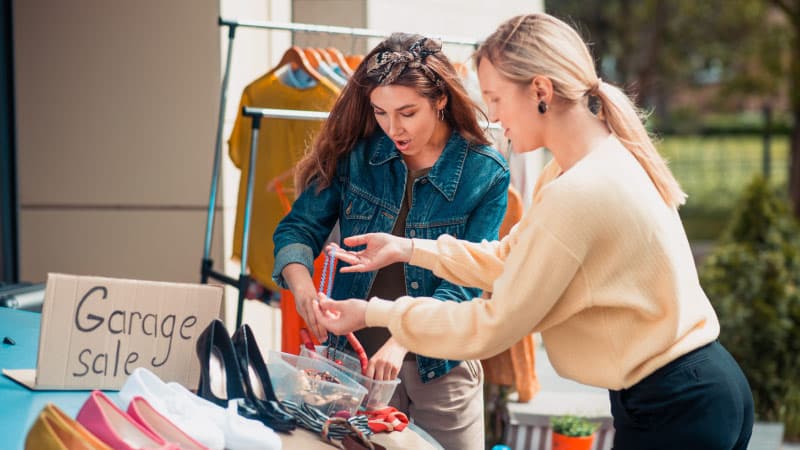 two women arranging items at their garage sale