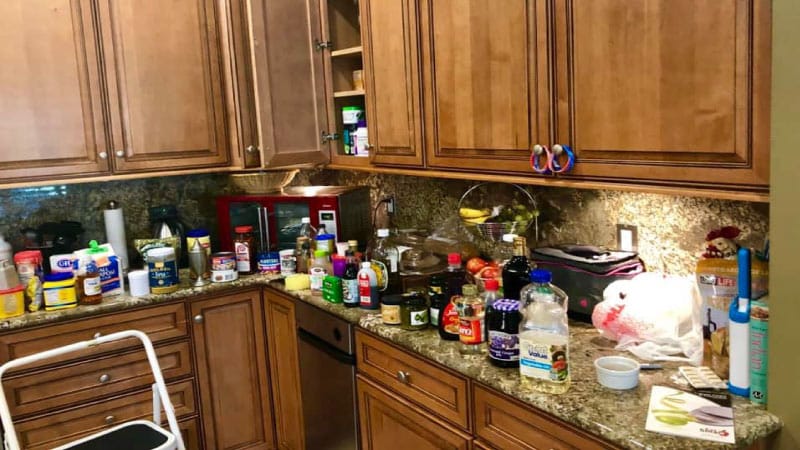 A kitchen in the middle of being decluttered and organized, with everything pulled out of the cabinets and placed on the countertops.