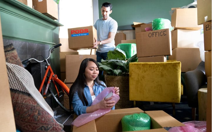 a couple packing moving boxes for their move to Minneapolis
