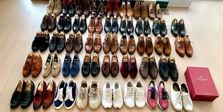 Over forty pairs of shoes are neatly arranged on a wood floor. 