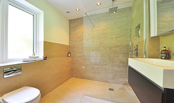 A simple, warm bathroom with a shower door so clear you can hardly see it.