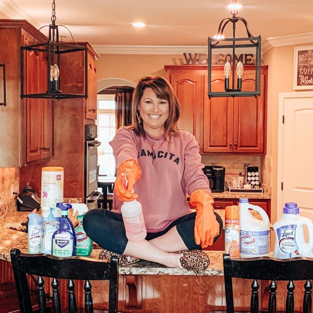 Woman coronavirus cleaning with cleaning supplies
