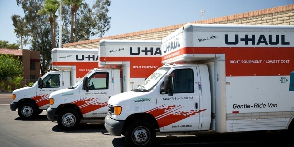 Three U-HAUL trucks are parked next to each other.