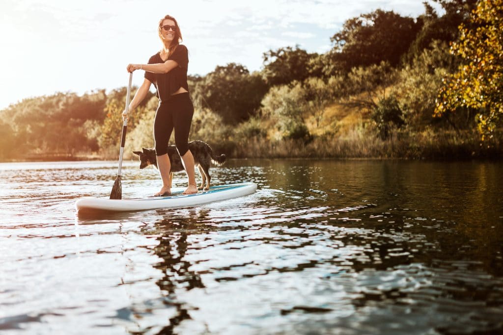 A woman paddle-boarding on a river in Austin, Texas