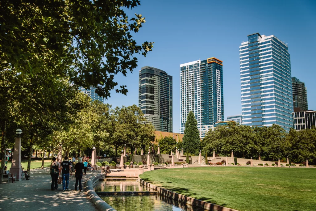 Park with grassy lawn and creek in front of skyscrapers in Bellevue